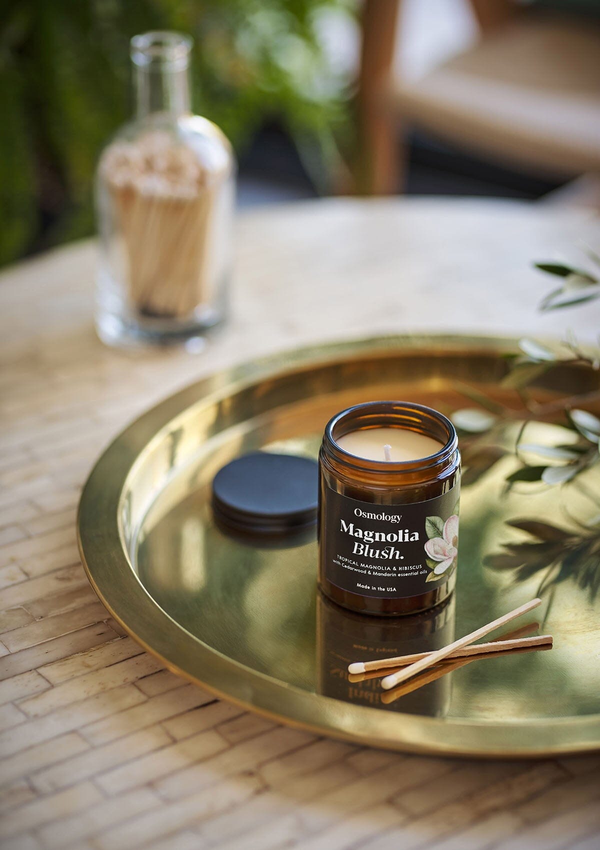 Magnolia Blush jar candle by Osmology on gold tray with match sticks