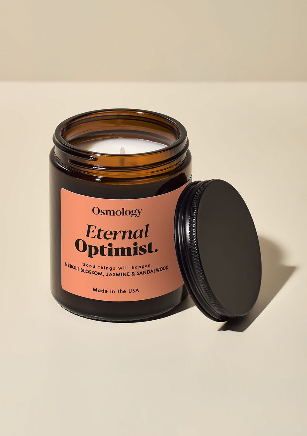 Osmology Eternal Optimist Jar Candle with lid off, on cream background