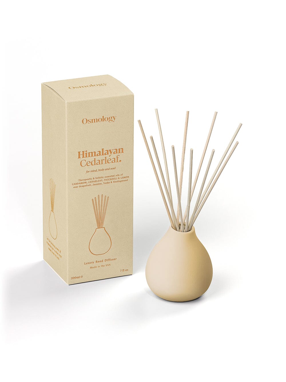 Osmology Himalayan Cedarleaf reed diffuser cream clay reed diffuser next to product packaging on a white background