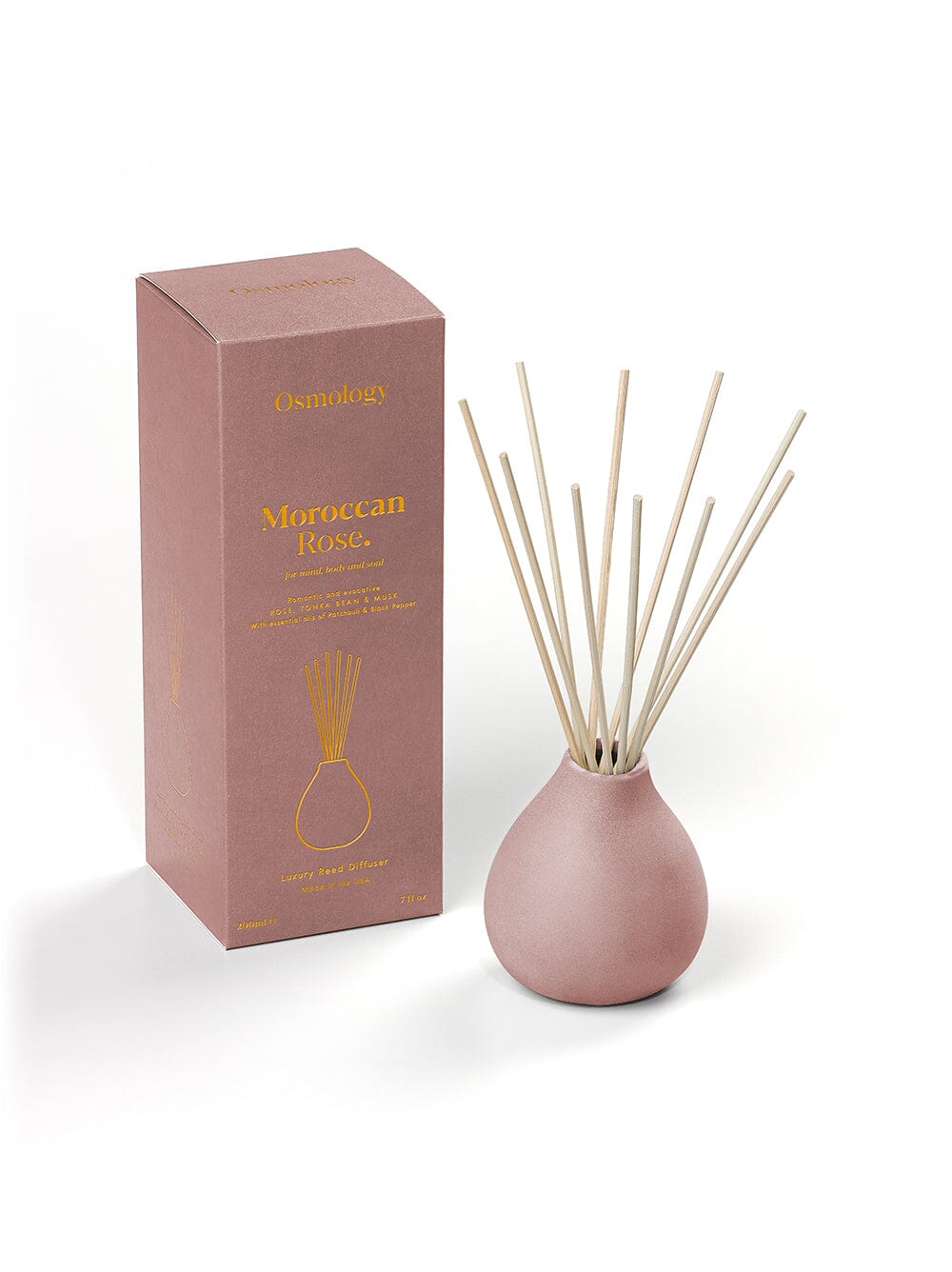 Osmology Moroccan Rose dusty pink clay diffuser with reeds next to product packaging on a white background